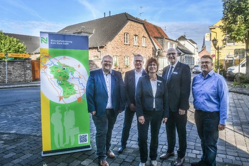Dirk Ketelaers (Bürgermeister Gemeinde Rheurdt), Prof. Dr. Peter Kisters (Vizepräsident für Forschung, Innovation und Wissenstransfer an der Hochschule Rhein-Waal), Brigitte Jansen (Geschäftsführerin Wirtschaftsförderung Kreis Kleve), Christoph Gerwers (Landrat Kreis Kleve) und Alexander Alberts (allgemeiner Vertreter des Bürgermeisters der Gemeinde Issum) stehen vor einem Banner des Kreises Kleve.