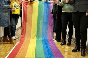 Die Gleichstellungsbeauftragten des Kreises Kleve halten eine Regenbogenflagge hoch