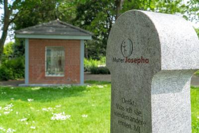 Mutter Josepha Steele mit Häuschen im Hintergrund