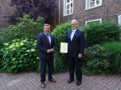 Clemens Brüx übergibt Gerhard Stenmans die Ehrenurkunde