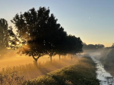 Sonnenaufgang über den Fleuthwiesen mit einem Spaziergänger